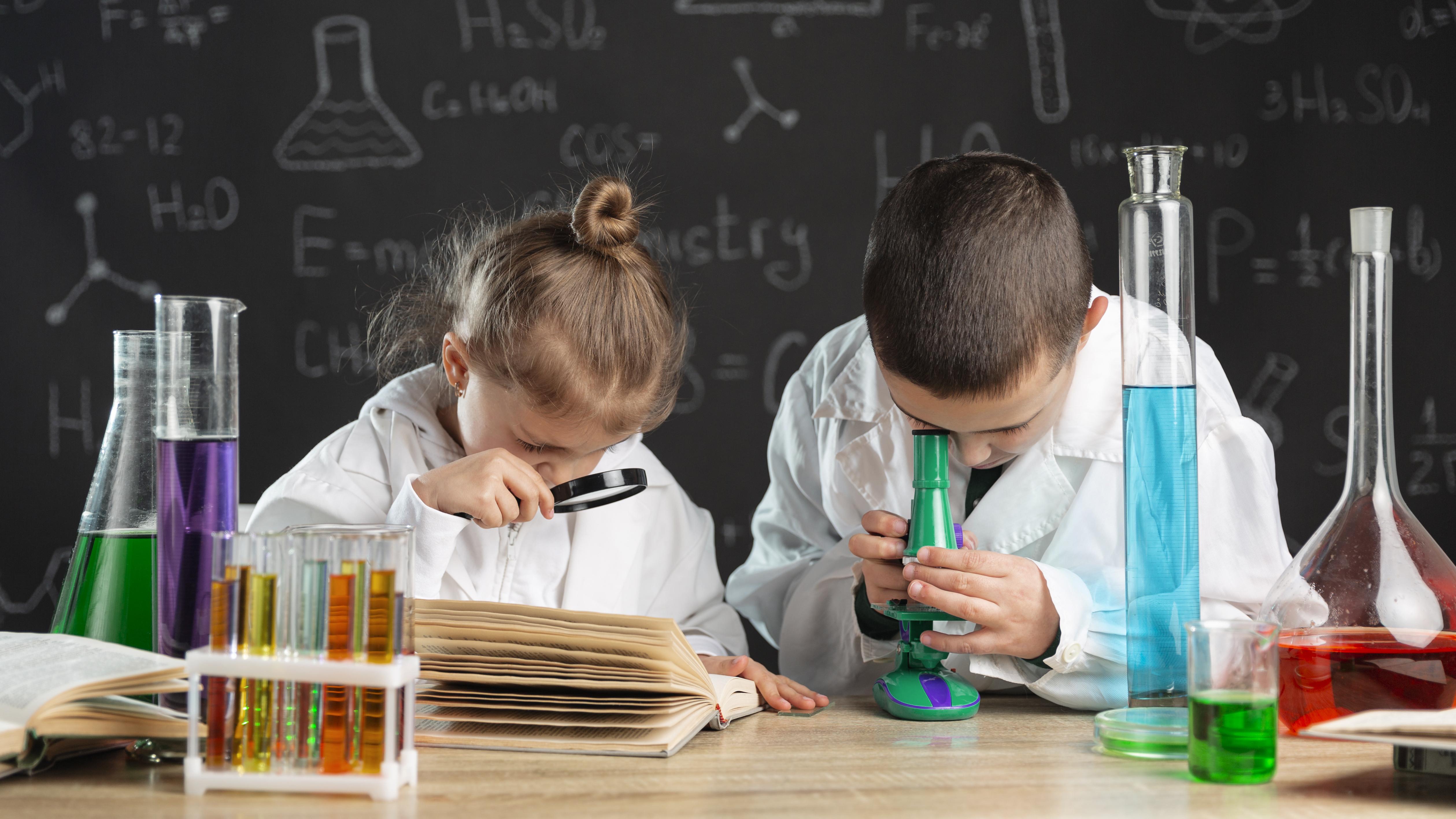 Niño y niña en clase observando y experimentando.