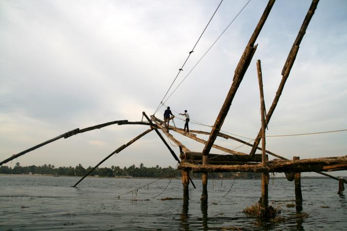 image Hombres hundiendo una red china en Cochin, Kerala, India