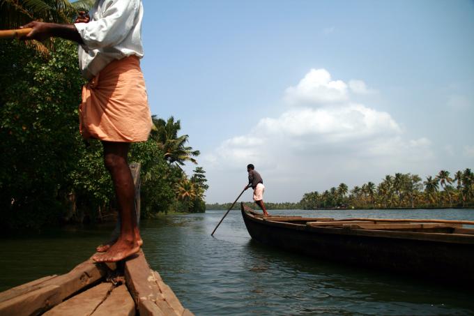 image Hombres manejando embarcaciones en los backwaters, Kerala, India