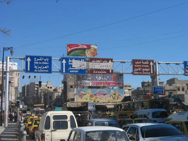 image Caos circulatorio y paneles informativos en el acceso a la ciudad de Alepo, Siria