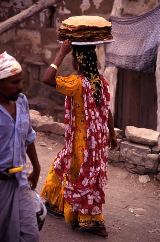 image Mujer llevando tortas de pan en el mercado de Suq al Khamis, Yemen