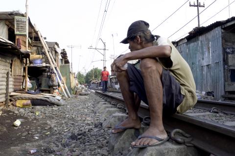 image Hombre sentado en las vías entre las estaciones de Senen y Kota, Yakarta, Indonesia