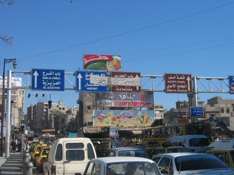 image Caos circulatorio y paneles informativos en el acceso a la ciudad de Alepo, Siria