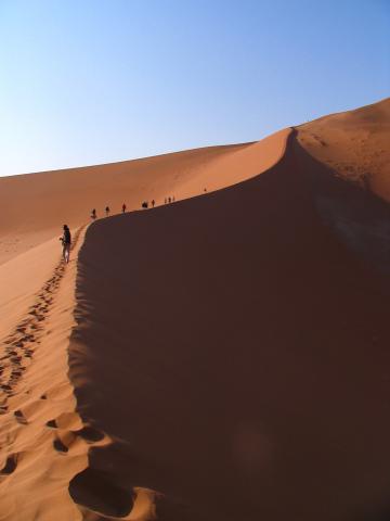 image Personas caminando sobre la Duna 45 del desierto de Namib, Namibia