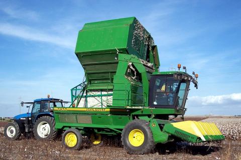 image Cosechadora volcando algodón sobre un tractor
