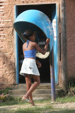 image Mujer habla en cabina de teléfono público, Quilombo, Sao Paulo, Brasil