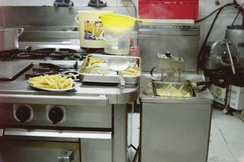 image Friendo patatas en cocina industrial