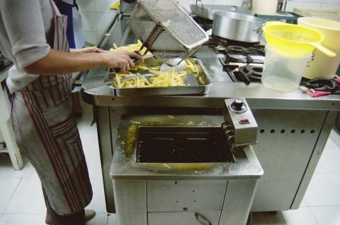 image Friendo patatas en cocina industrial