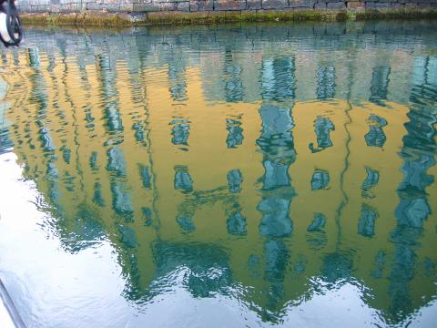 image Reflejos del hotel Bryggen sobre las aguas del puerto de Aalesund, Noruega