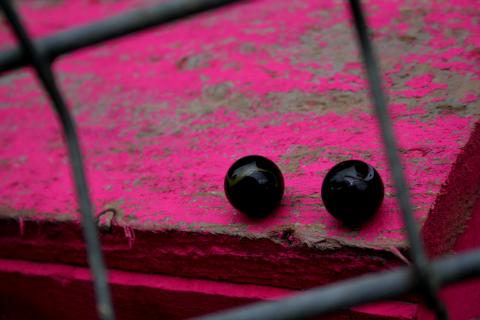 image Canicas negras sobre superficie rosa