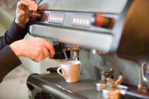 image Persona preparando un café en la máquina del Larios Café, Madrid